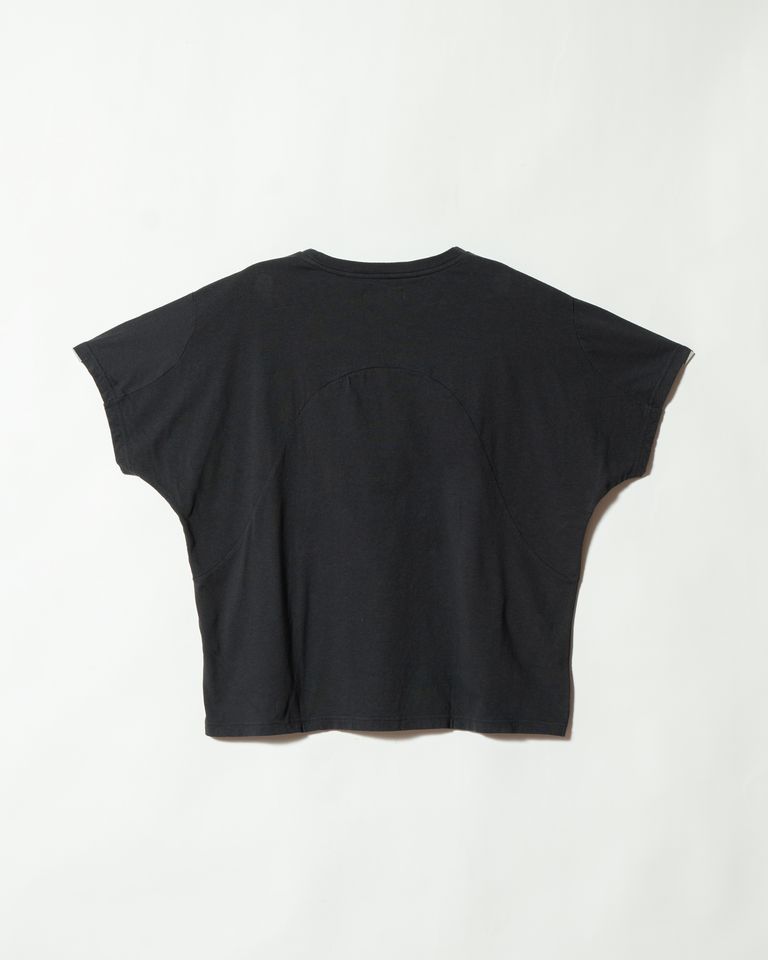 背面の全体像。バック中央に大きくアーチを描く切り替えラインが走り、フロントとは異なる表情を見せる。このアーチが背中に適度なゆとりをつくり出し、動いたときに生地が突っ張らない。シンプルに見えて、前・後・袖と3つのパーツが複雑に組み合わさった構造体であることがわかる。