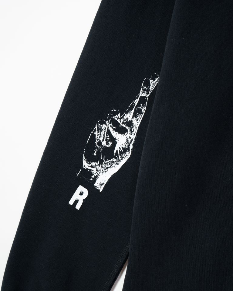 RAF SIMONSのジップアップフーディは、コットン100%の素材を使用しており、裏毛パイルの着心地の良さが特徴です。両肘にはRSハンドサインのグラフィックが施され、ユニークでアイコニックなデザインとなっています。また、RSのレザーパッチが付いており、ブランドの高級感を演出しています。 生地切り替え部分は切りっぱなしの仕上げとなっており、こだわりを感じるディテールに仕上がっています。