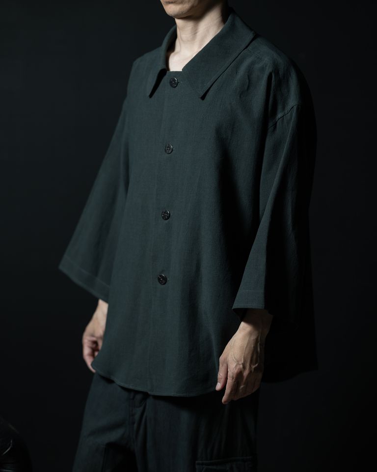 横から見ると、前後差のあるラウンド裾と袖の落ち感が分かりやすい。腕を自然に下ろした位置でシルエットが最も美しく整う。パンツとの境目がはっきり出るヒップ丈で、同色のワイドパンツと合わせるとセットアップとして機能する。