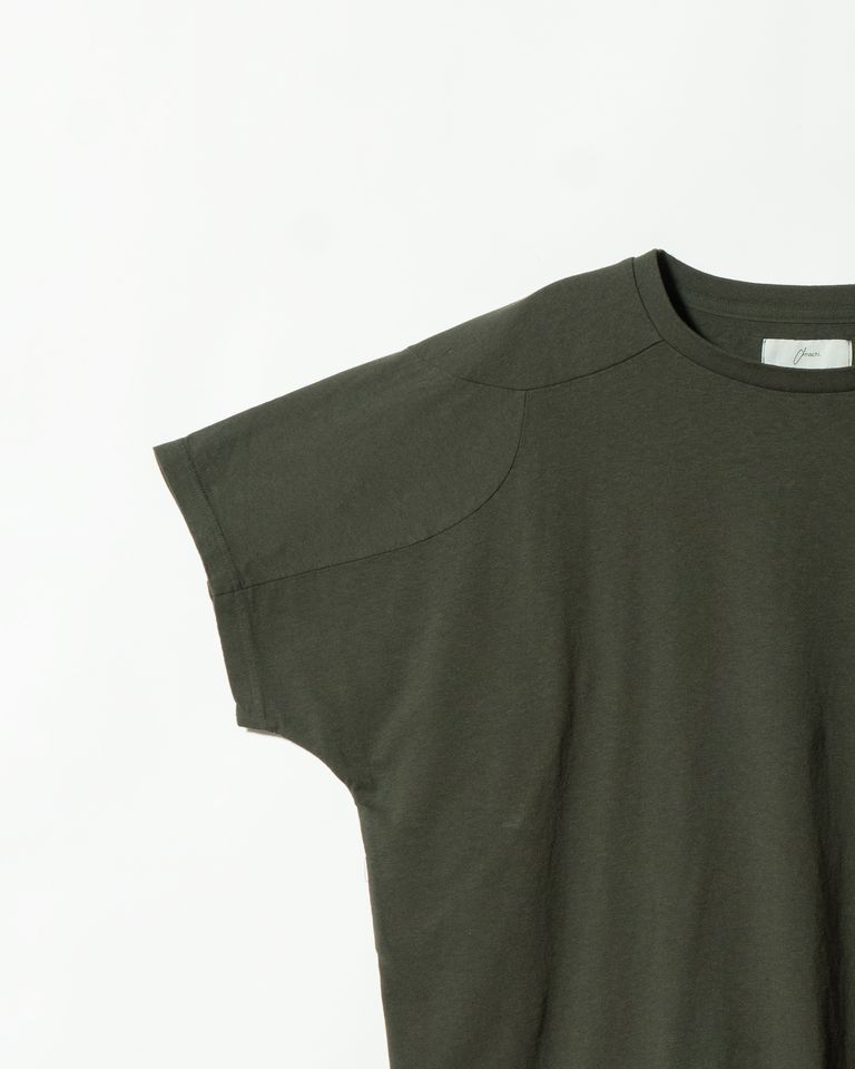 前身頃とショルダーヨークの切り替えラインを捉えたディテールカット。曲線を描くステッチが肩の丸みに沿って走り、Tシャツとは思えない立体的な仕立てが確認できる。同一素材ながら生地の方向を変えることで、光の当たり方にわずかな差が生じ、それ自体がデザインになっている。