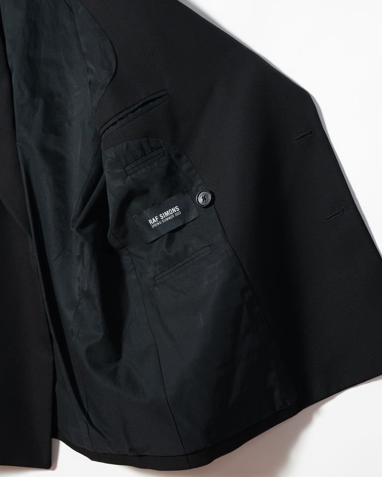 RAF SIMONSのダブルブレストブレザーは、独特のピーコック・ラペルが特徴。最終コレクションで、アーティストのフィリップ・ヴァンデンバーグとのコラボアイテムが融合。彼のグラフィックプリントアイテムと組み合わせることで、モダンで個性的なスタイリングが実現。ファッションとアートが融合した新しいスタイルを楽しめます。