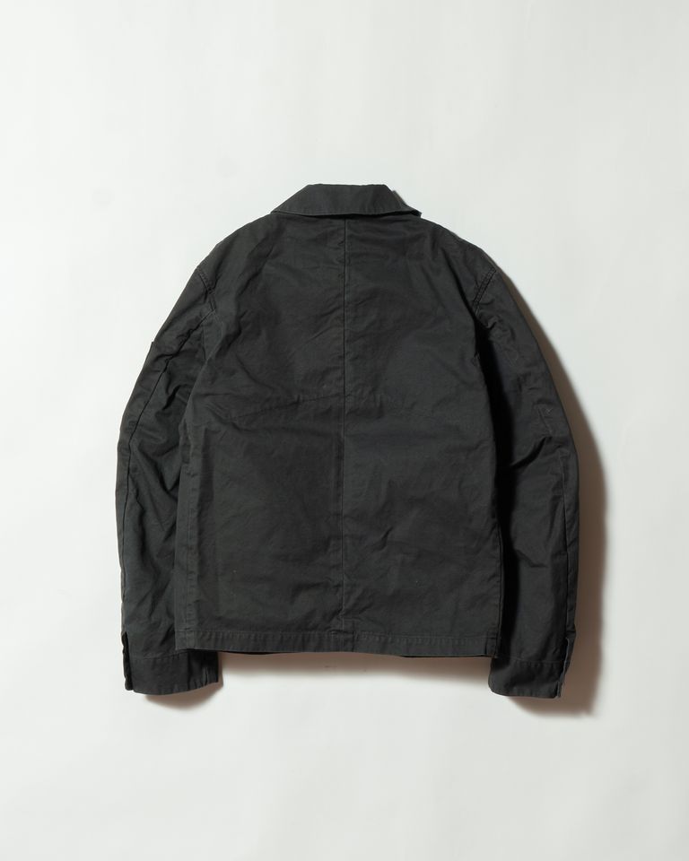 背面は装飾を抑えたシンプルな構造。FINXギャバジンの美しい表情と、バイオ加工による自然なシワ感が引き立ちます。ミリタリー由来の機能性と、現代的なミニマルデザインが融合した仕上がりです。