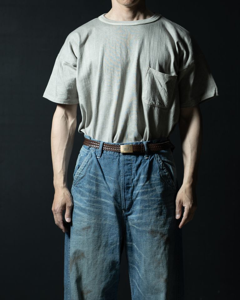 ブレイデッドレザーベルトを使ったタックインスタイルの正面アップ。墨染めのグレーグリーンとブラウンのベルト、ゴールドバックルが互いを引き立て、着こなし全体に渋みのある統一感をもたらす。