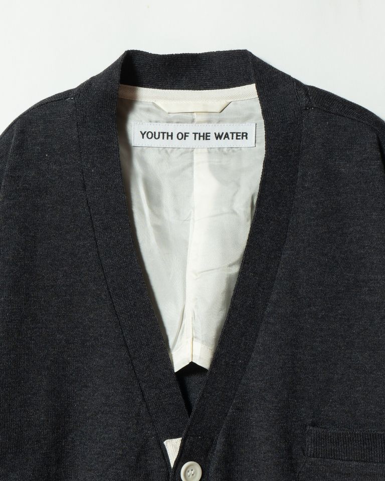 ネック内側には「YOUTH OF THE WATER」のネームタグ。背裏にはテーラリングの手法を応用し、キュプラ裏地を配しています。軽やかな着心地と、見えない部分への配慮が共存します。