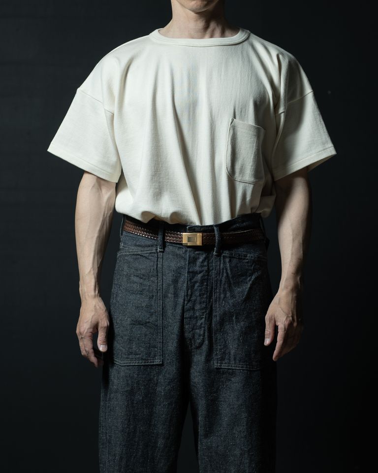 ブレイデッドレザーベルトをタックインして合わせたスタイリング。ビッグシルエットのTシャツをあえてデニムにインすることで、腰位置が強調されメリハリのあるシルエットに。ゴールドのバックルが上質感を添える。