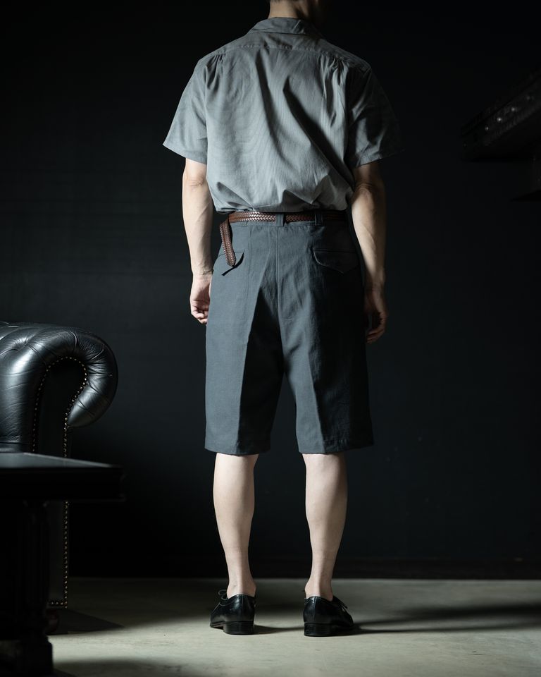 後ろ全身からのショット。背面にも美しいラインが通っており、どの角度から見ても絵になるシルエット。バックポケットのフラップが上品なアクセントを添え、1950年代のミリタリーデザインの面影を残す。