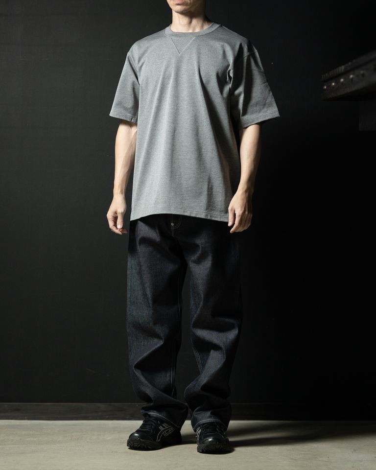 カルフォルニア綿を100％使用したT シャツです。紳士服やモーニングコートなどでよく見られる肩線や脇線を後ろに移動させ、前から見た時にシームが見えなくなり、フォーマルに仕立てる仕様をT シャツに採用しています。脇部分にマチを付けているので、タックインをした状態から袖を上げても裾が外に出ない構造になっています。
