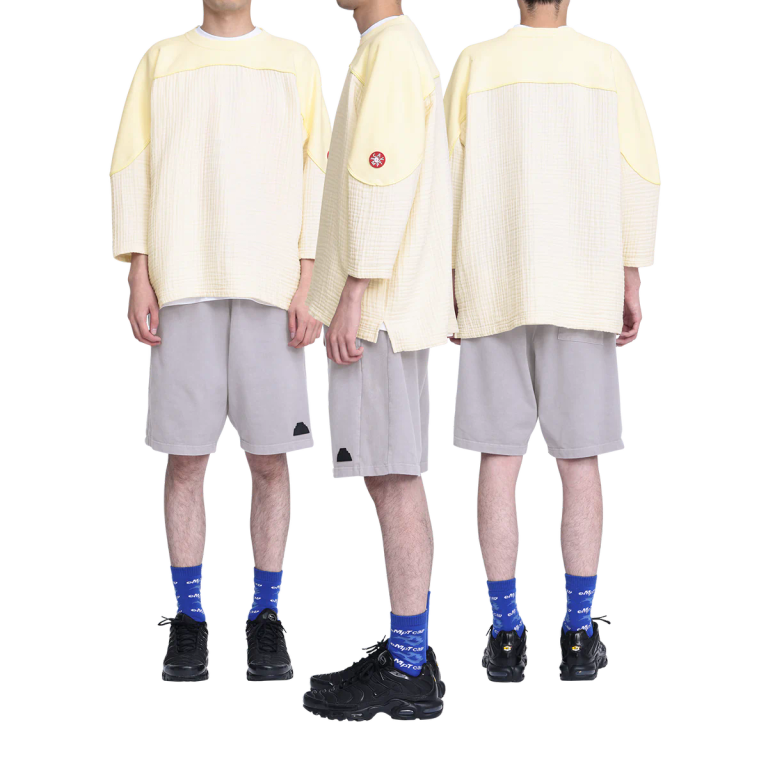 100%コットン。ガーゼ生地。プルオーバー。クルーネック。後ろ身頃ショルダーに刺繍でCAVEMPT。左袖上部にシリコンパッチ。身頃上部で色・生地切り替え。切り替え部分にパイピング。裾脇にスリット。ワイドシルエット。ウォッシュ加工。日本製。