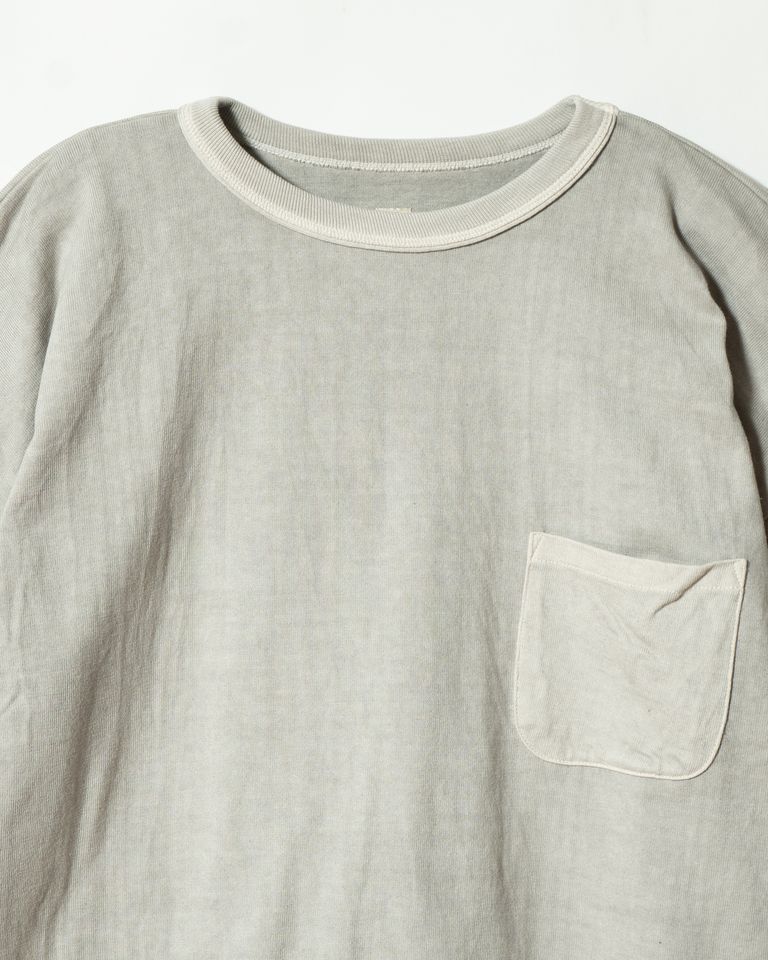 墨染めが施された身生地と、染まらずに生成りのまま残ったネックリブ・胸ポケットのコントラストが鮮明に確認できるクローズアップ。二重仕立てのリブに染料が淡く滲み、染めの奥深さが際立つ。