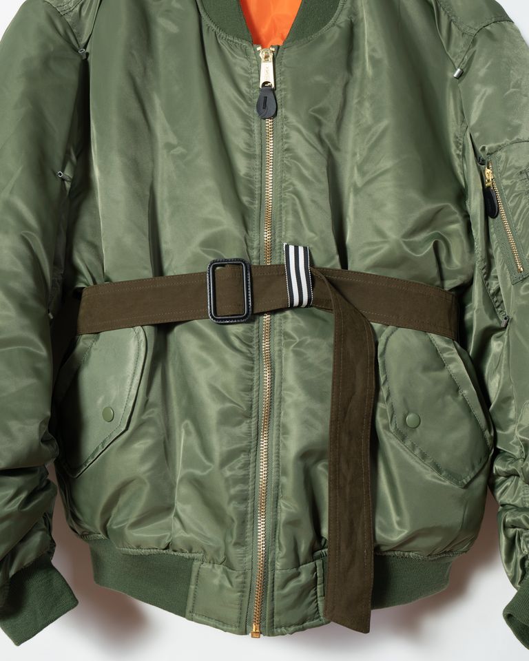 MY BOMBER - Customized bomber jacketは、マリナ イーがデザインしたオリジナルのカスタムMA-1ジャケットです。クラシックなMA-1デザインをベースに、マリナ イーならではの個性的なアクセントが加えられています。特徴的なコートに付いているようなベルトがウエスト部分に配置され、シルエットやスタイリングに変化をもたらしています。