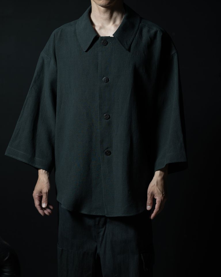 168cm・着用サイズ4。身幅69cmが肩から腕にかけて空気を含むように広がり、シャツというよりアウター的な存在感がある。ボタンを全て閉じた状態でも首元に余裕があり、インナーを選ばない。ディープグリーングレーは、暗所でより深みが増す色。