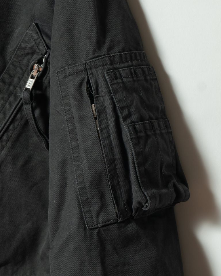 袖にはミリタリージャケットを想起させるユーティリティポケットを配置。実用性を確保しながらも過度な主張を抑え、全体のミニマルな印象に調和する設計となっています。