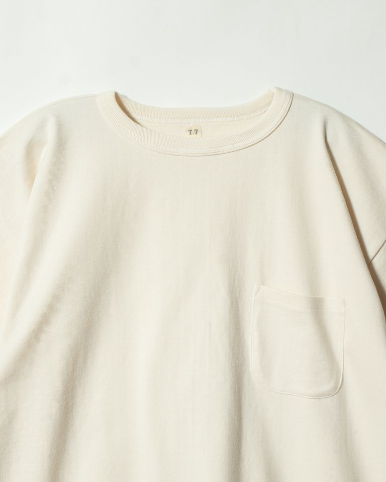 二重仕立てのネックリブと「T.T」ブランドタグが映える首元のディテール。伸び止めを意識した設計は、当時の実用的なものづくりを忠実に再現。大正時代から受け継がれる吊り編み生地の豊かな表情が間近で確認できる。