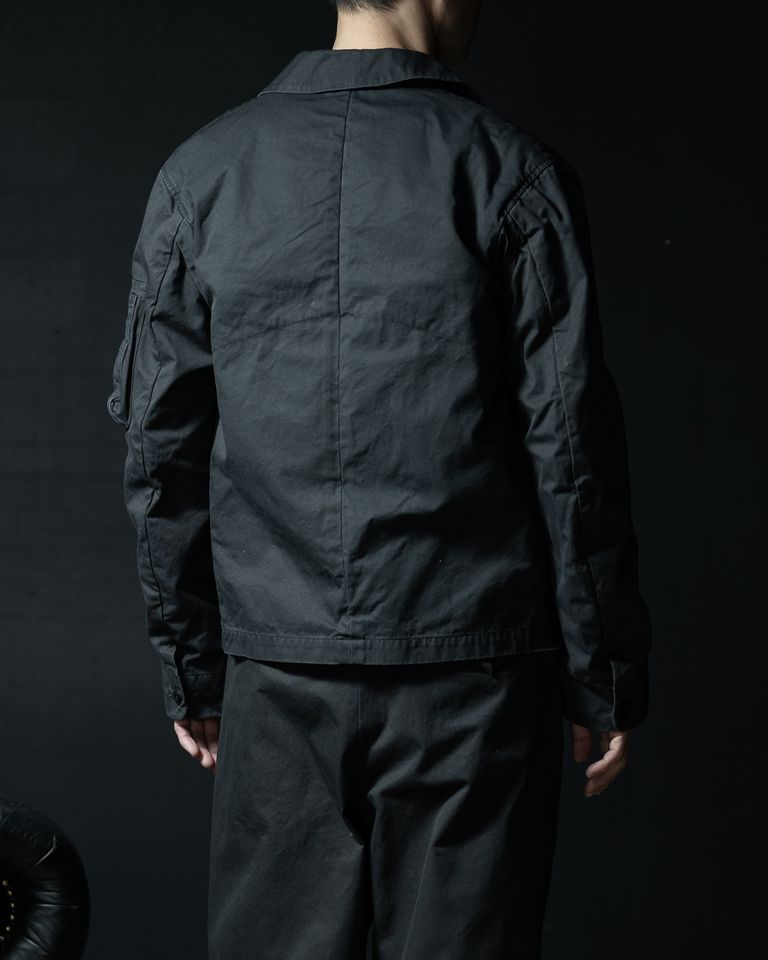 背面は装飾を抑えたシンプルな構造。ミリタリージャケットの機能性をベースにしながら、テーラリングの技術によって整えられた自然なシルエットが特徴です。FINXギャバジン特有の滑らかな質感とバイオ加工による柔らかな風合いが、落ち着いた存在感を生み出しています。