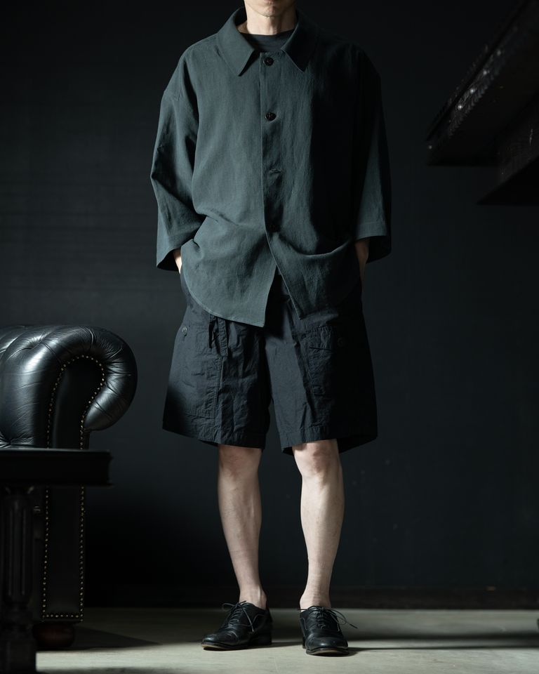 amachi.のコートシャツ（リネン70%/シルク30%）との同ブランドコーディネート。ディープグリーンのコートシャツとチャコールブラックのショーツは近似色でまとめ、素材の質感差だけで立体感を出している。