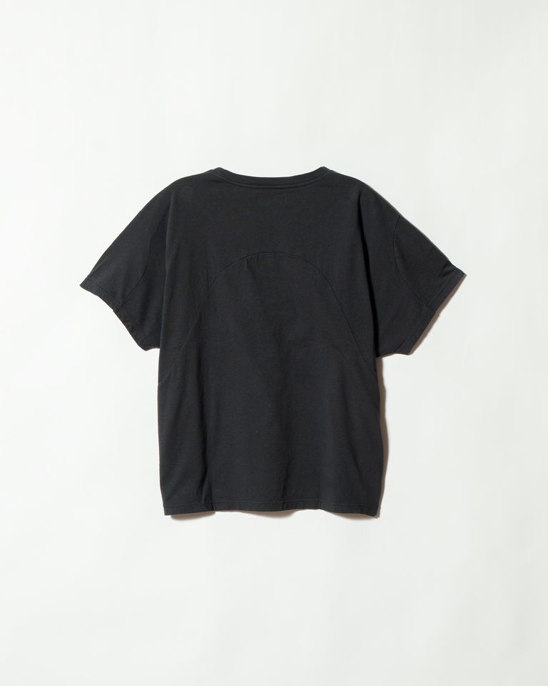 背面のアーチ型切り替えと、脇下からバックへつながるパターンラインが明瞭に確認できる。ドルマン調の袖付けにより裾に向かって自然に広がるシルエットが、平置きでも見て取れる。縫製の精度と生地のハリ感も確認しやすいカット。