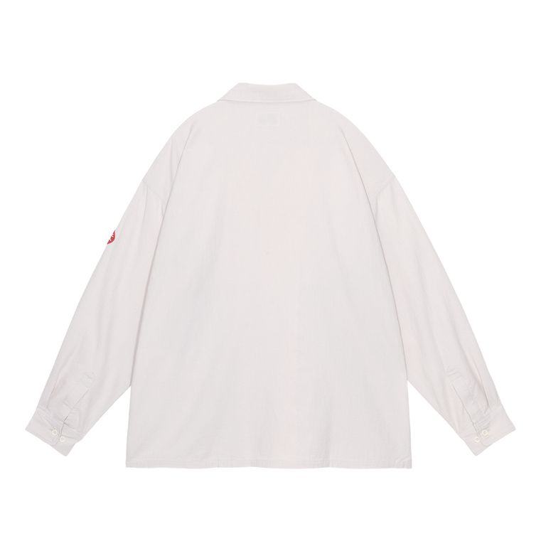 グレー展開の背面はオフホワイトがかったニュートラルトーン。光の当たり方によってわずかに表情が変わるコットンツイルの質感が、ナチュラルかつ上質な雰囲気を醸し出す。シンプルな後ろ姿だからこそ、素材と縫製の丁寧さが如実に伝わる一枚。羽織りとして使っても様になるボリューム感。