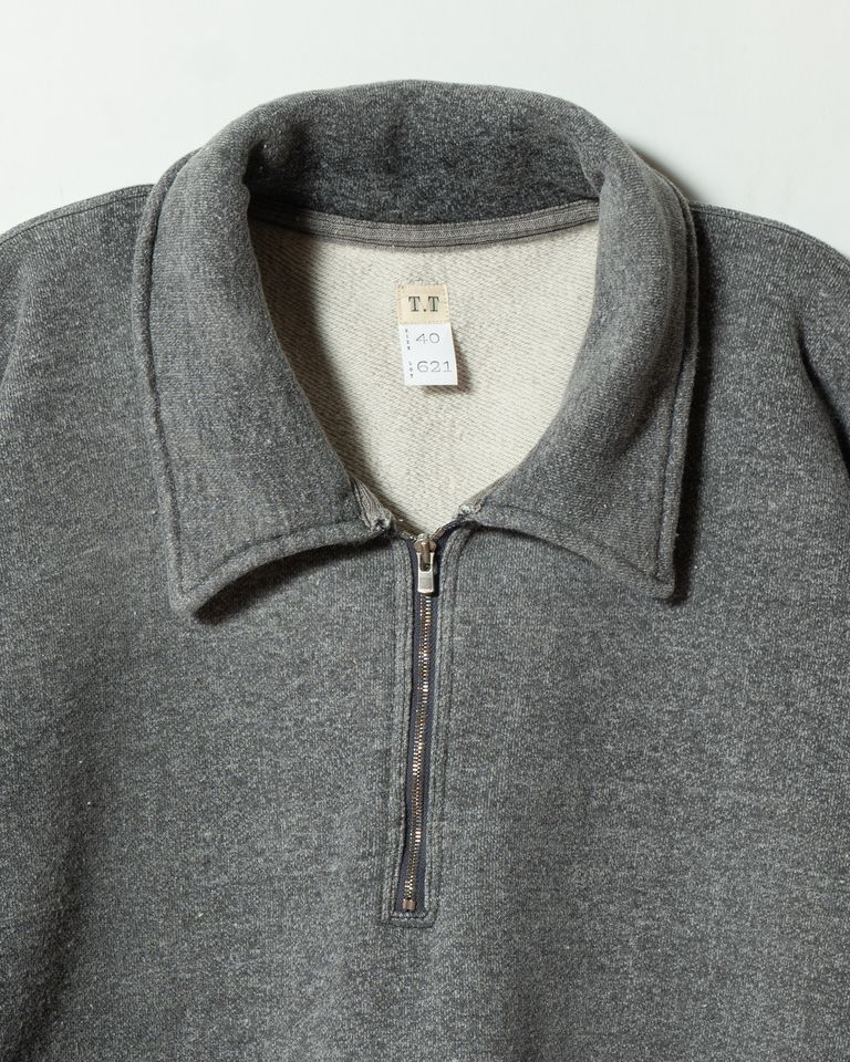 一枚仕立ての衿は洗いをかけることで自然なヨレ感が生まれる仕様。ファスナー引き手はアールデコ調の筋刻印をオリジナルで制作したもの。1950年代に急速に普及したジッパー文化をそのままディテールに落とし込んでいる。T.Tのタグも確認できる。
