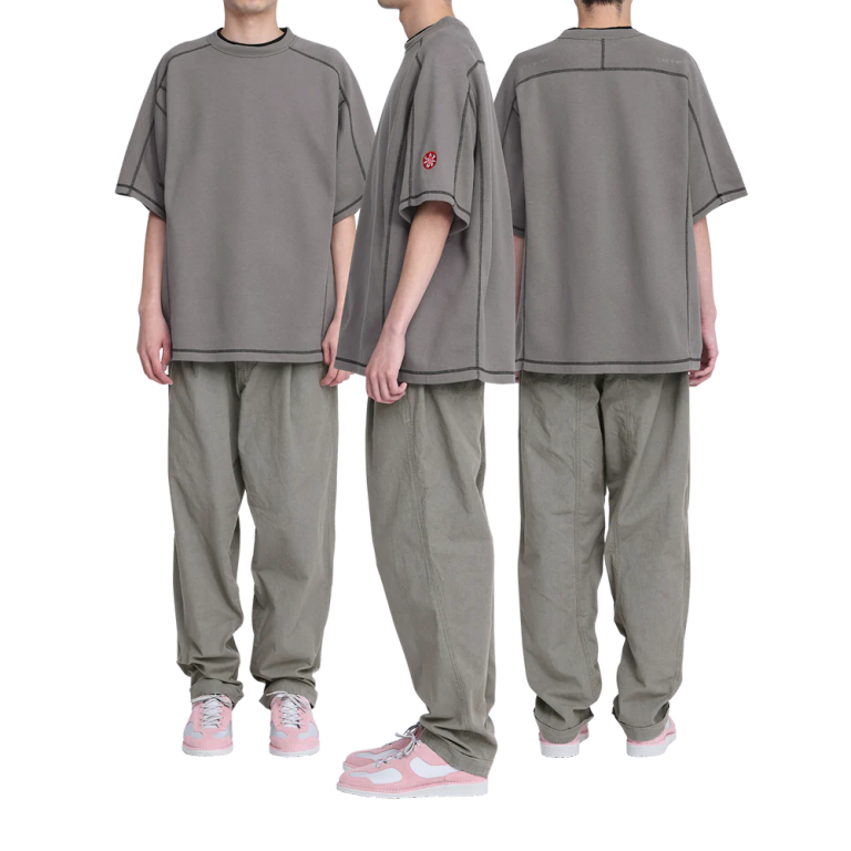 100%コットン。二重編み生地。ショートスリーブ。クルーネック。プルオーバー。変形ラグランスリーブ。後ろ身頃ショルダーに刺繍でCAV EMPT。左袖上部に刺繍でグラフィック。コントラストステッチ。ウォッシュ加工。チャコール、イエローの2色展開。日本製。