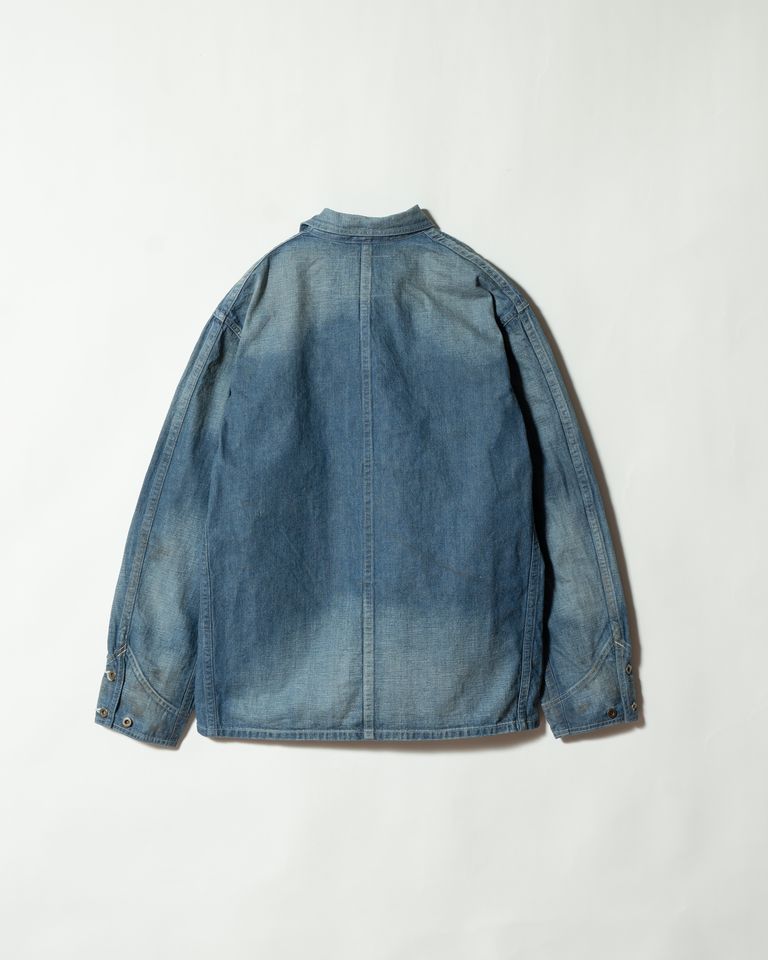 バックスタイルのフラット全体像。センターシームが背中のラインを引き締め、当時の構造的なパターンの正確な再現を示す。袖口の鉄製ボタンは未メッキで錆びが育ち、インディゴの褪色とともに唯一無二の表情を形成していく。