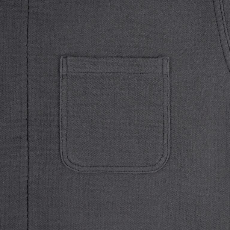 前身頃右胸のパッチポケットクローズアップ。丸みを帯びたコーナーステッチと、コットンガーゼ特有の微細な凹凸が生み出す陰影が、シンプルな形の中に豊かな表情を宿している。素材の柔らかさと縫製のしっかりとした仕上がりが、日本製ならではのクオリティを示す一カット。