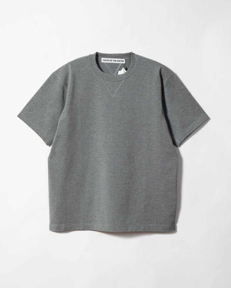 カルフォルニア綿を100％使用したT シャツです。紳士服やモーニングコートなどでよく見られる肩線や脇線を後ろに移動させ、前から見た時にシームが見えなくなり、フォーマルに仕立てる仕様をT シャツに採用しています。脇部分にマチを付けているので、タックインをした状態から袖を上げても裾が外に出ない構造になっています。