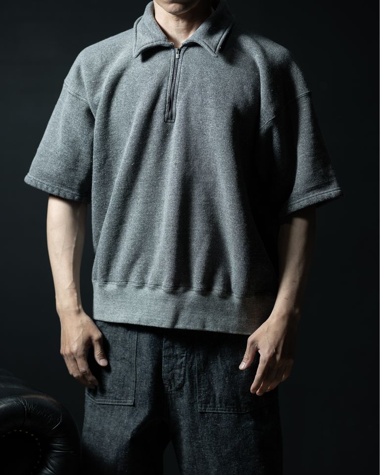 身長168cm・体重55kgのモデルがサイズ40を着用。ゆとりのある身幅と短めの袖丈が、現代的なオーバーサイズのシルエットを形成。ハーフジップを閉じた状態では衿が程よく立ち、スウェット以上の存在感を発揮する。