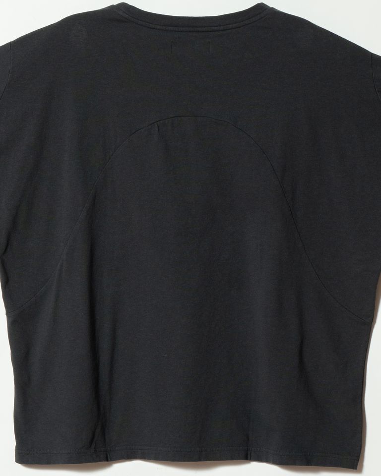 背面中央のアーチ型切り替えを間近で捉えたカット。ミシン目が均一で丁寧な縫製が確認できる。生地同士の接合部でわずかに素材の表情が異なり、単色でありながら奥行きのある背面をつくり出している。amachi.のパターンへのこだわりが最も如実に表れる部分。