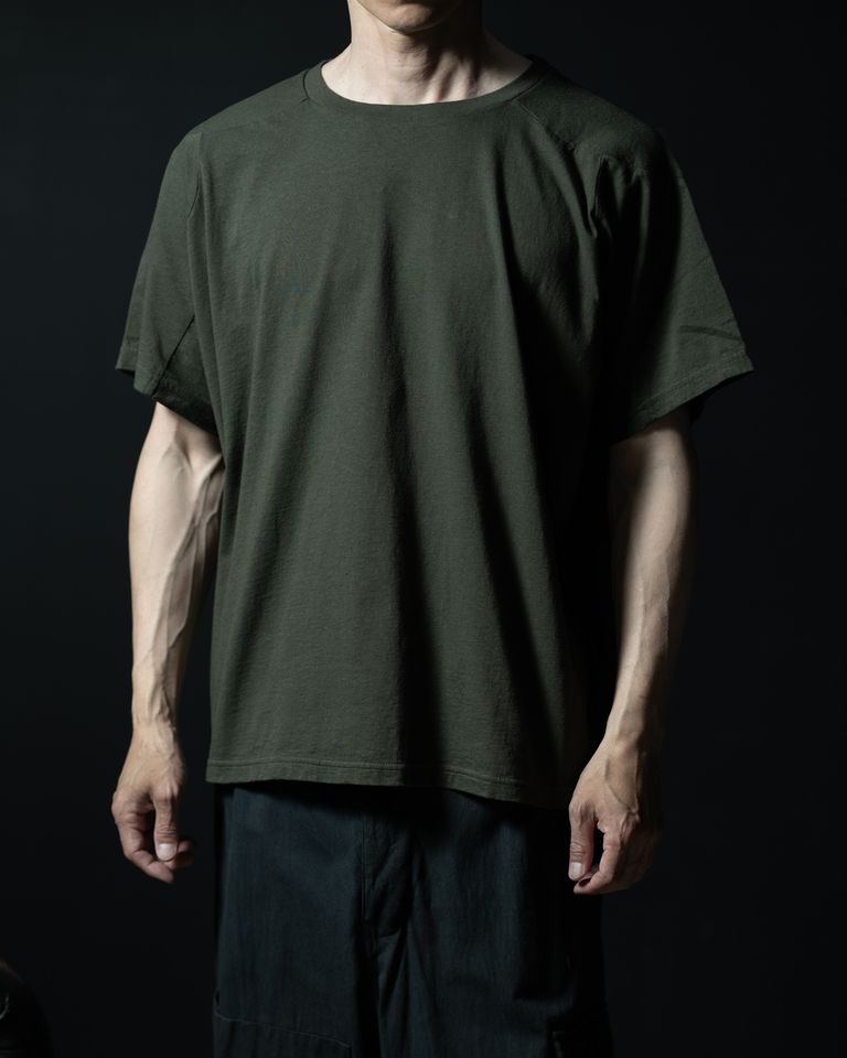 ドルマン調の袖付けにより肩まわりに余裕があり、体に沿わず少し浮くように落ちるシルエットが確認できる。首まわりのリブは細く、ネックラインが大きめに開いているため、すっきりと清潔感のある印象。