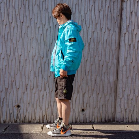 通気性と防水・防風性のある膜を極薄のポリエステルの層でカバーした三層構造の高性能軽量生地で作ったフード付きブルゾン