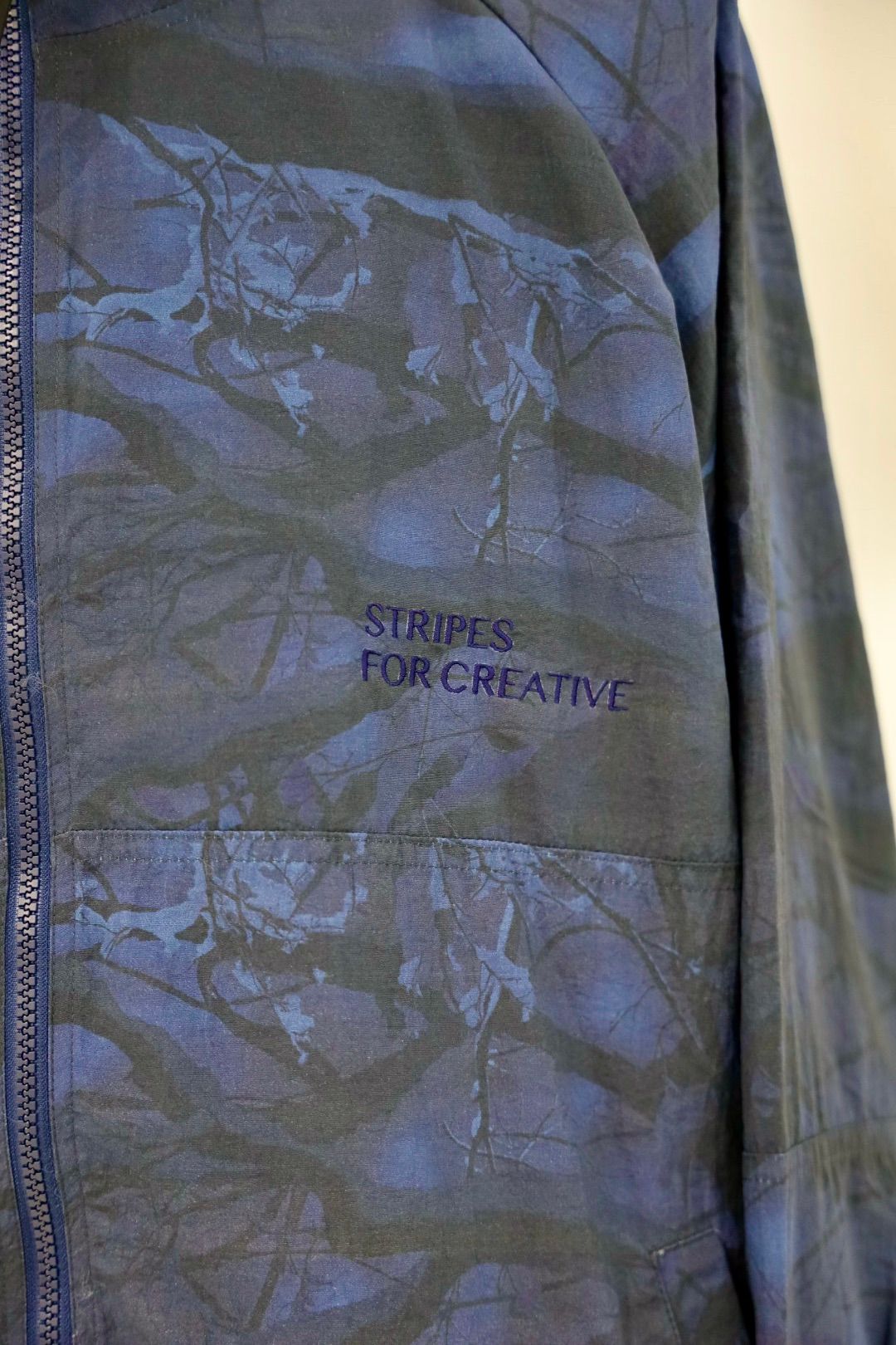 S.F.C 25FW エスエフシー WINDBREAKER JACKET (REAL TREE CAMO) (SFCFW25J06)Navy Tree Camo