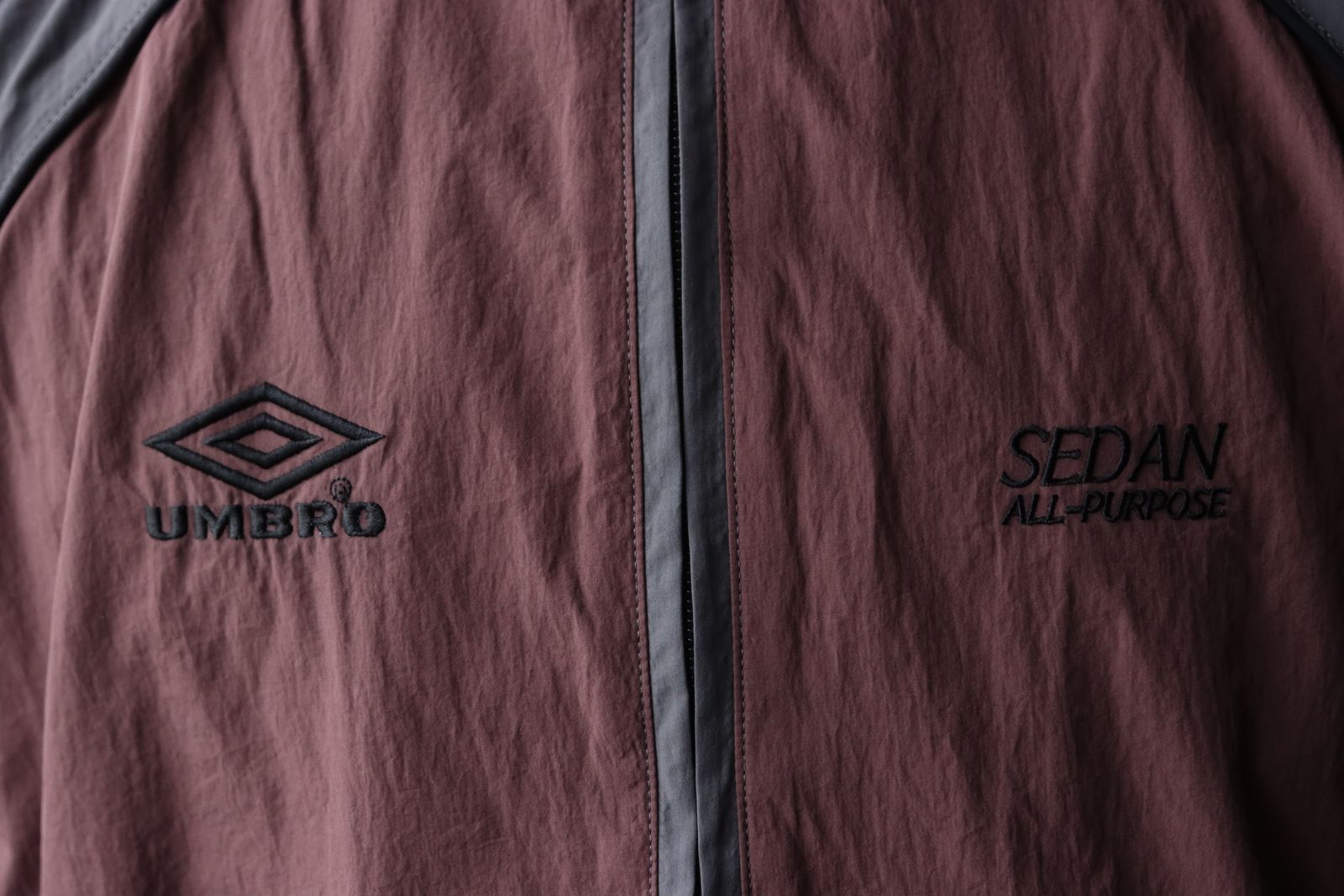 セダンオールパーパス SS24 UMBRO® Woven Track Jacket(SD24S-JK05)Charcoal Brown☆3月9日(土)発売！
