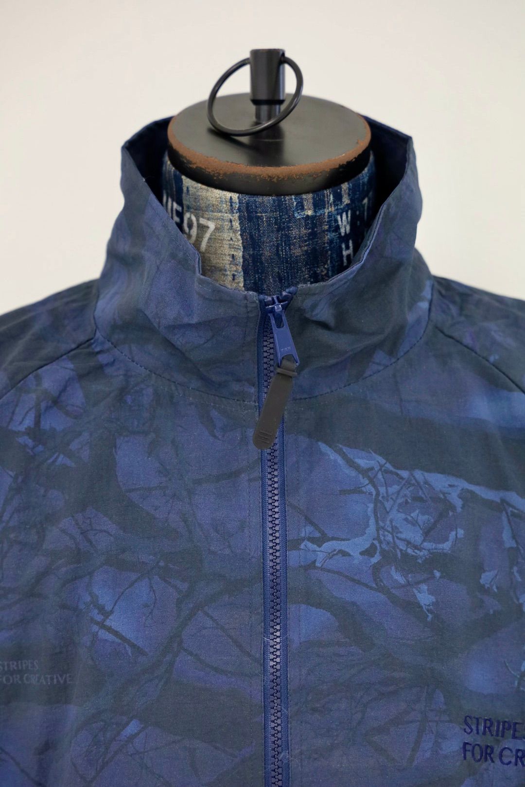 S.F.C 25FW エスエフシー WINDBREAKER JACKET (REAL TREE CAMO) (SFCFW25J06)Navy Tree Camo