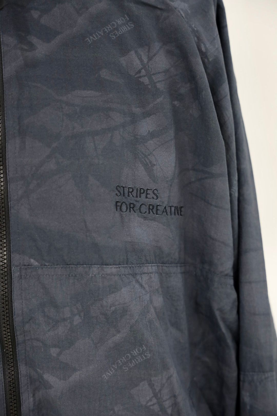 S.F.C 25FW エスエフシー WINDBREAKER JACKET (REAL TREE CAMO) (SFCFW25J06)Black Tree Camo