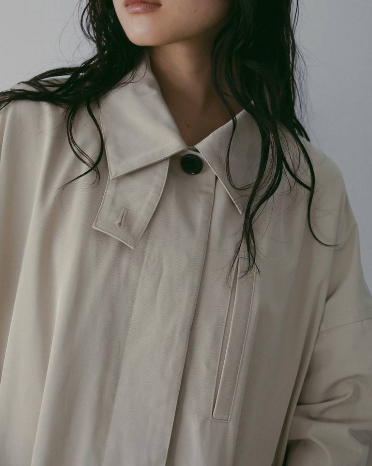 model.164cm / size.38 比翼仕立てのフロントは、閉じるとミニマルに、開けて羽織れば配色の大きめボタンがさりげないアクセントに。