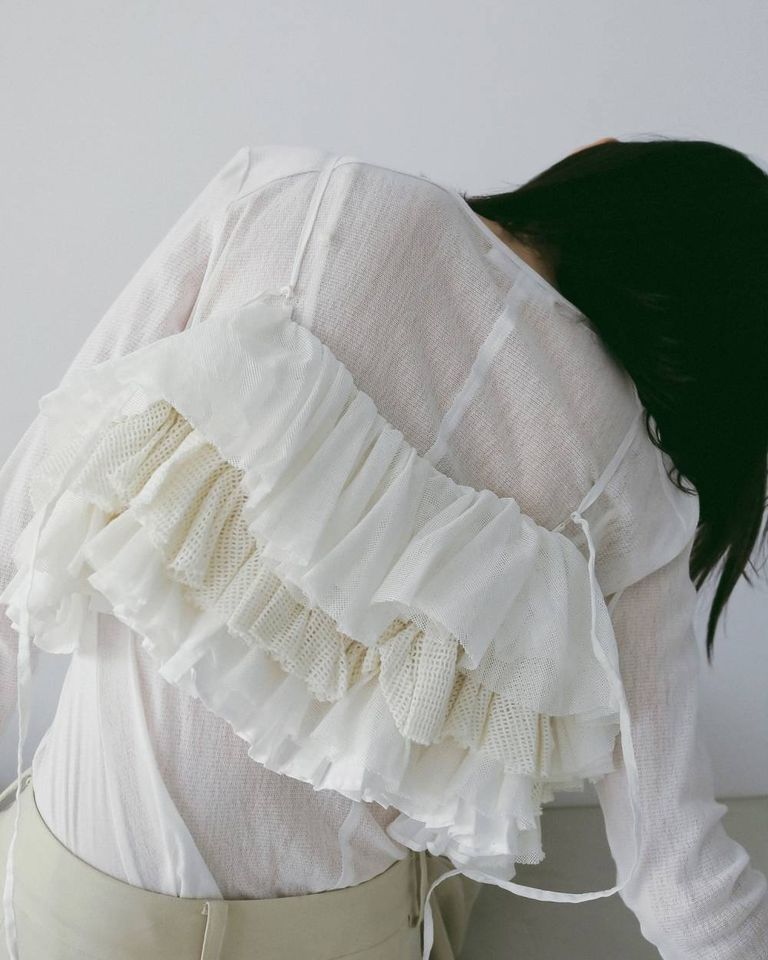 結び目から垂れるディテールが、後ろ姿にもさりげないアクセントを添えます。