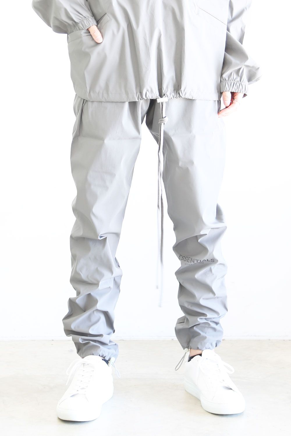 FEAR OF GOD ESSENTIALS 2023SS Track Pants Off Black エッセンシャルズ トラックパンツ オフブラック ナイロンパンツ 中綿 ドローストリング ラバーロゴ 裾ジップ チャコールブラック サイズM【231113】【新古品】【me04】