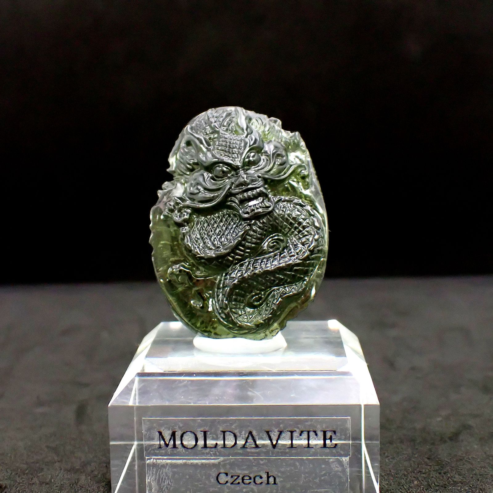 ◇龍彫刻◇モルダバイト 発見地:旧チェコスロバキア アクリル台座付き 77.90ct(15.58g) / 13.9x29.7x41.7mm前後 [260632497]